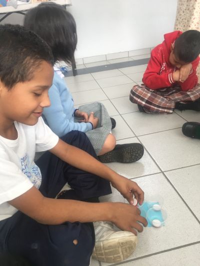 Estudiantes jugando un juego de braille en el piso